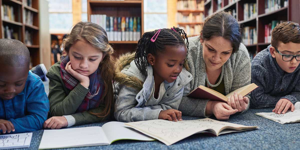 teacher reading to students in the library